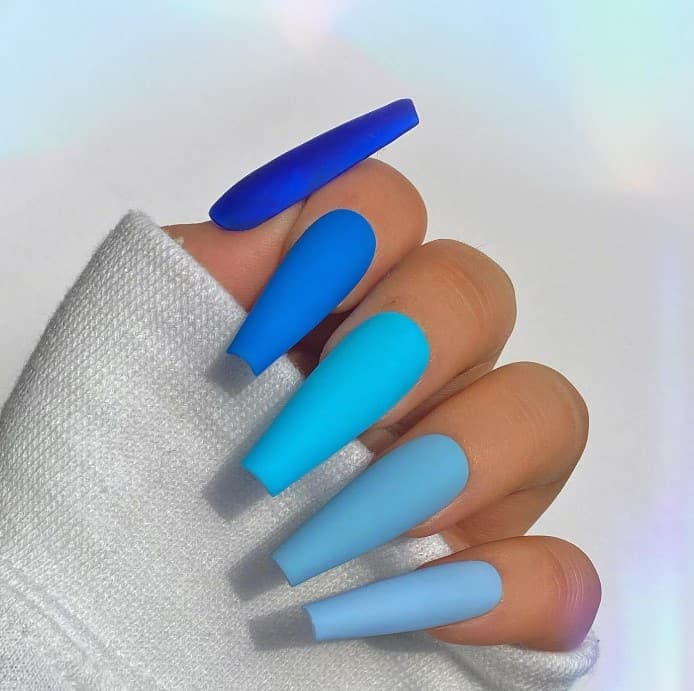 A hand with matte set in a gradient of blue shades