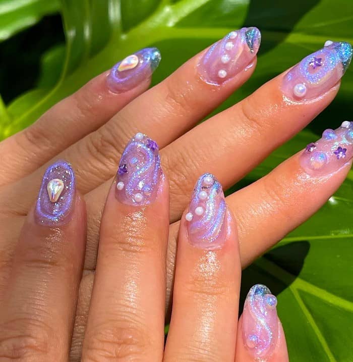 beach design nails with glittery purple swirls, 3D purple stars, gems, and pearls on clear nails, it's a purple fantasy that's sure to wow 