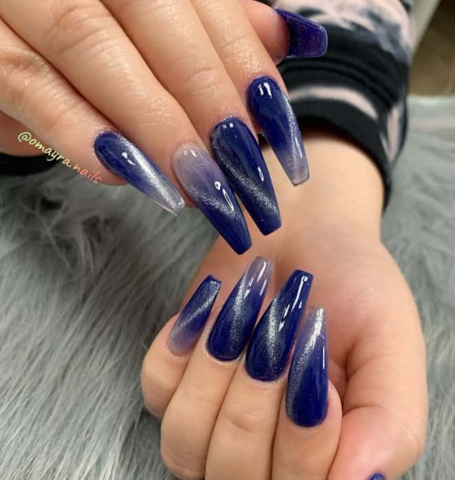 A woman's hands with darker base coat with an ombre fade and diagonal silver cat irises on nails