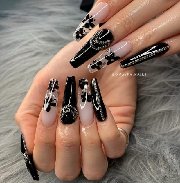 a solid black and creamy white base with clear tips with white flowers and silver foils