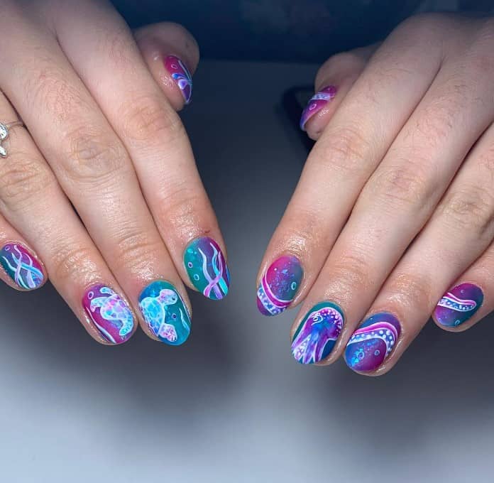 nails that flaunt a linear purple-and-blue-green gradient base and white octopus and turtle nail art