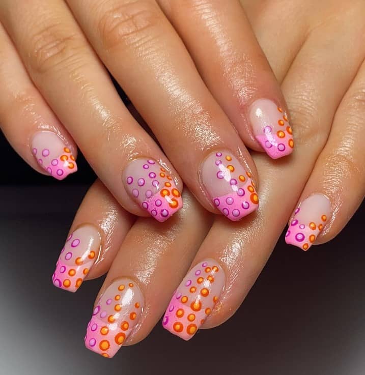 A woman's pink nails with this mesmerizing bubble-inspired nail design in pink, orange and purple
