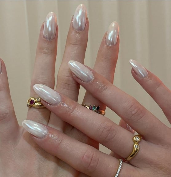 A woman's hands with classic beige-glazed donut nails are finished with a pearlescent sheen
