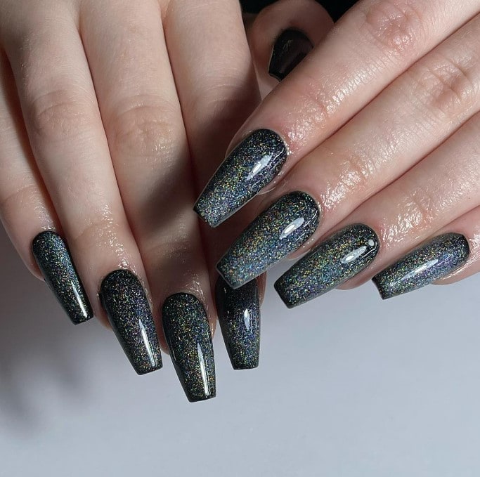 A woman's nails with stellar display of a cat-eye effect where fine magnetic particles show a rainbow of colors
