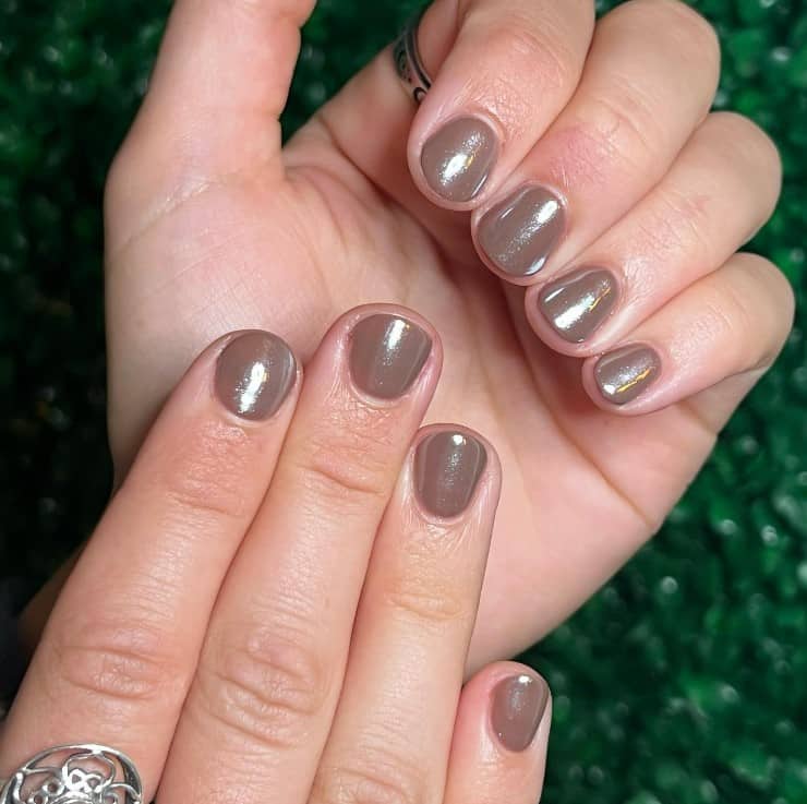 A woman's nails with chocolate base topped off with a glossy, glazed finish