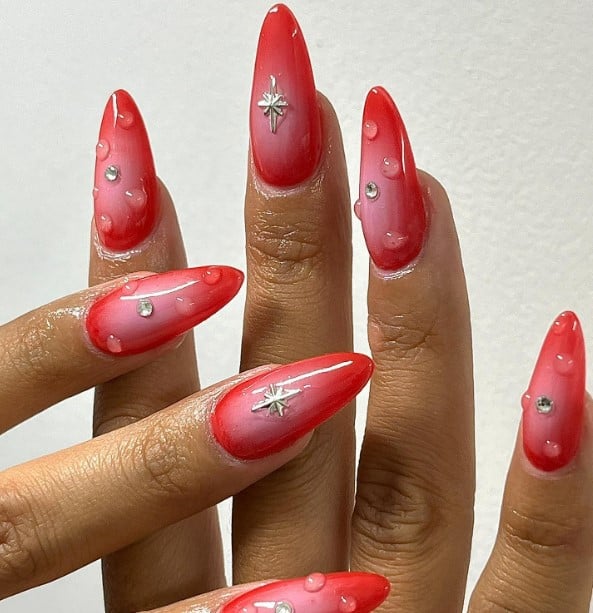 pink ombre nails where each nail is dotted with centric silver rhinestones, with the accent nail decorated with a silver north star stud