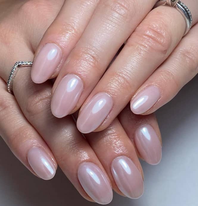 A woman's nails features pearlescent round nails in a nude color