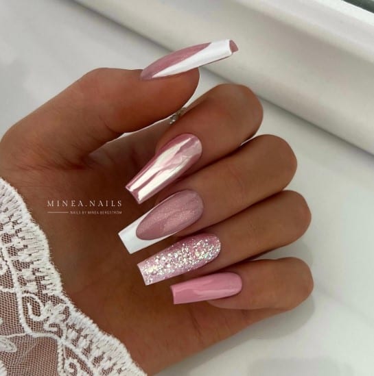 A woman pink nails painted with French tip on one, chrome nail powder on another and leaving the rest plain and sparkly