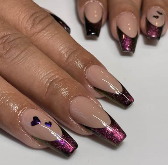 A woman's nails with cat-eye nail design featuring long coffin nails in peach with red-violet cat-eye French tips