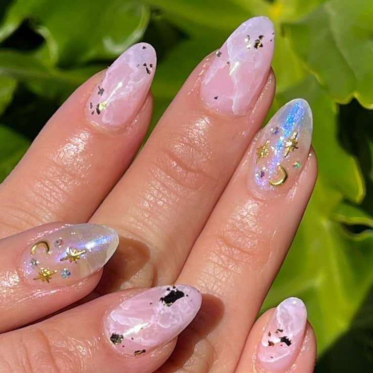 A woman's pink marble nails and gold nail arts.