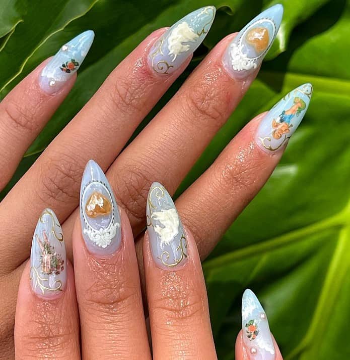 A woman's long almond nail has crisp images of angels, cloudy skies, and additional accents of a white horse head and a 3D heart nail charm