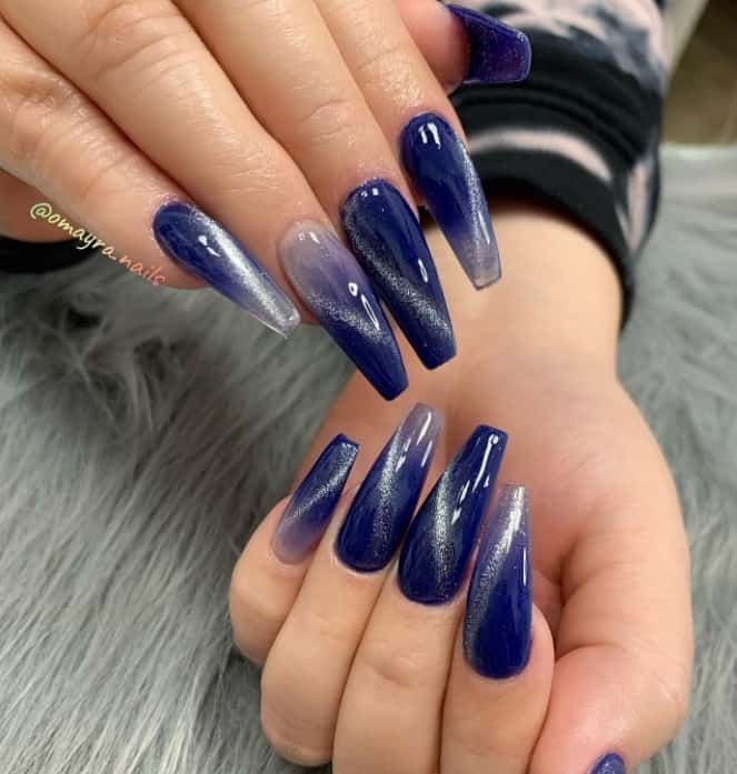 A woman's hands with coffin cat-eye nail design marries the dramatic flair of long coffin nails with the serene beauty of a base with a blue-and-white ombré