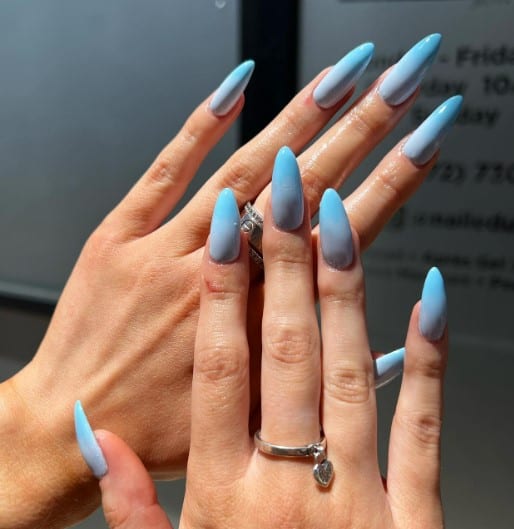 A woman with light blue nail base transitioning to baby blue 