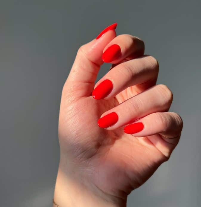 A woman's hand with a red manicure.