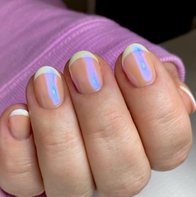 A woman's glazed donut nails with this set's shimmery nude nails and white tips