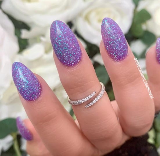 A woman's hand with combining both vibrant colors, with blue being the accent through the sparkles