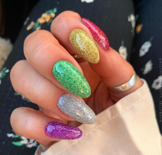 A woman's long oval nail flaunts a different hue of the rainbow, with silver standing as a sparkling outlier