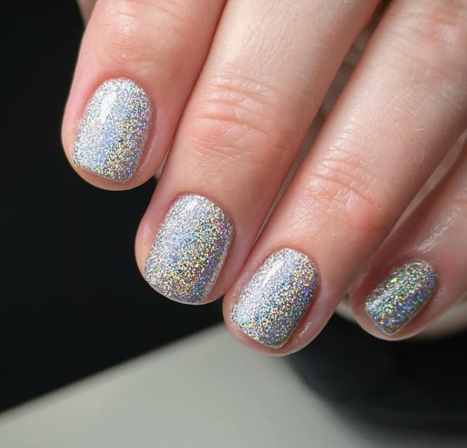 A woman's short glitter nails become mini disco balls with this dazzling design