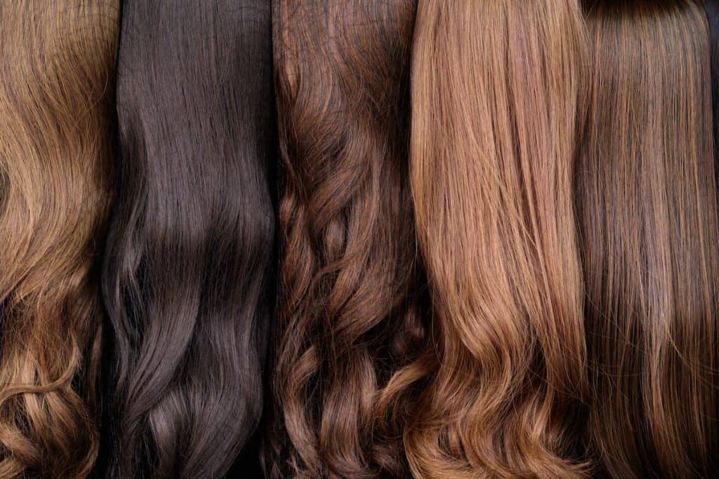 Close up brown and another color of hair wigs display in beauty salon.
