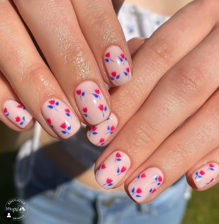 Delicate magenta tulips with deep indigo stems and leaves dance across each nail, creating a miniature canvas of floral art that's both quaint and captivating.