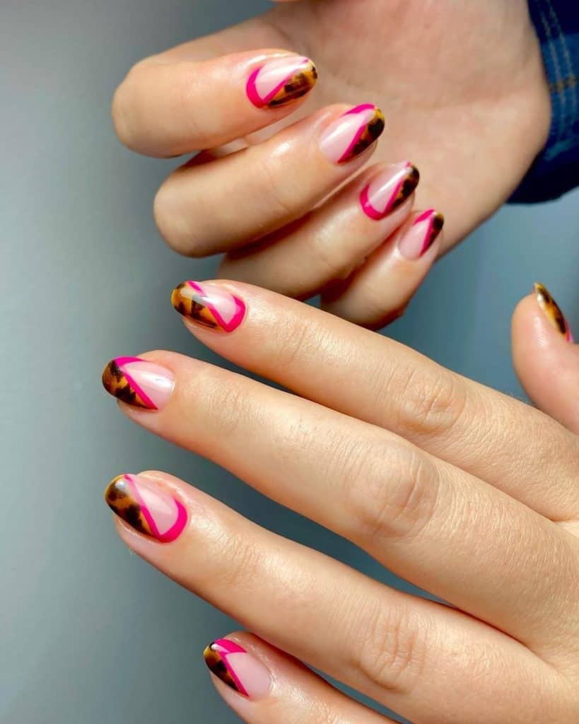 A woman's hands with nude base and diagonal tips with tortoiseshell patterns boldly outlined by magenta polish.