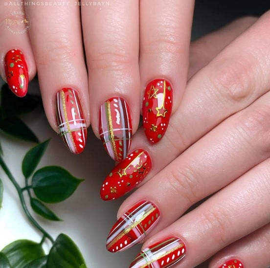 A woman's nails with red and white stripes on them.