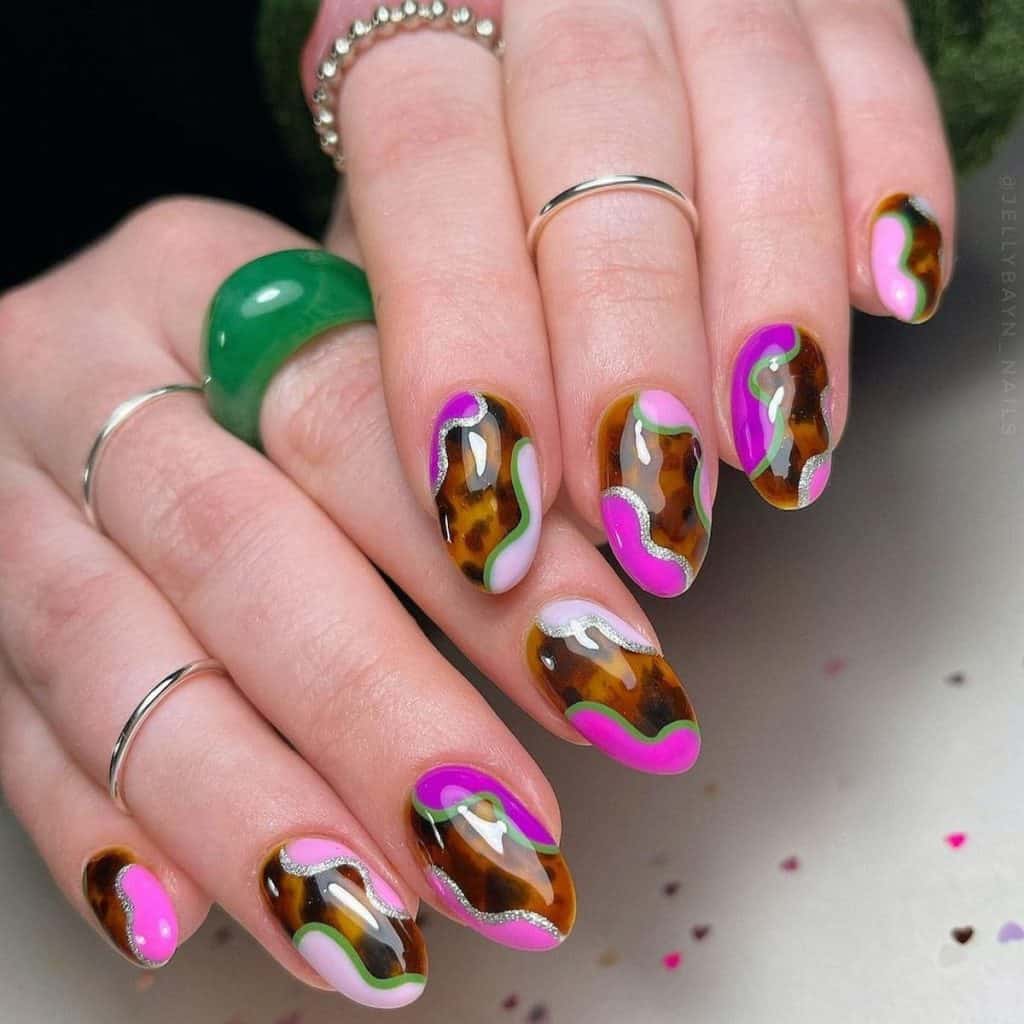 A woman's nails with tortoiseshell base and purple, pink, and magenta blobs near the edges