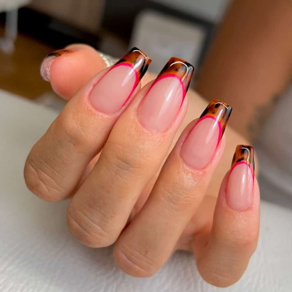 A woman's nails with pink and brown designs.