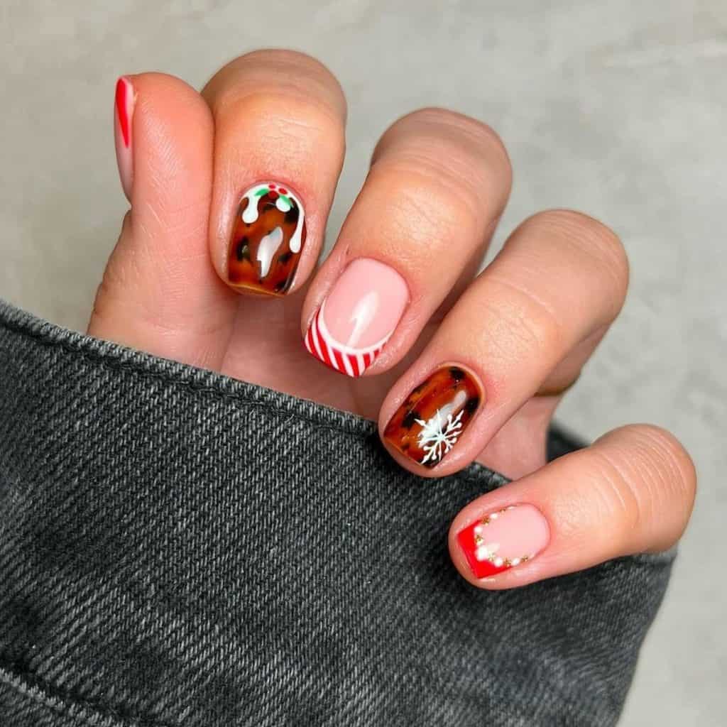 A woman's hand holding nude ones nails with red French tips with either candy cane stripes or a white and gold dotted outline