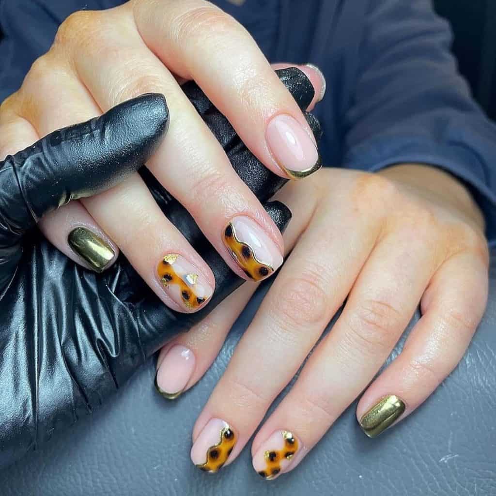 A woman's gold tortoiseshell nails, where chrome gold swirls, wavy tortoiseshell patterns, and delicate gold foil blobs