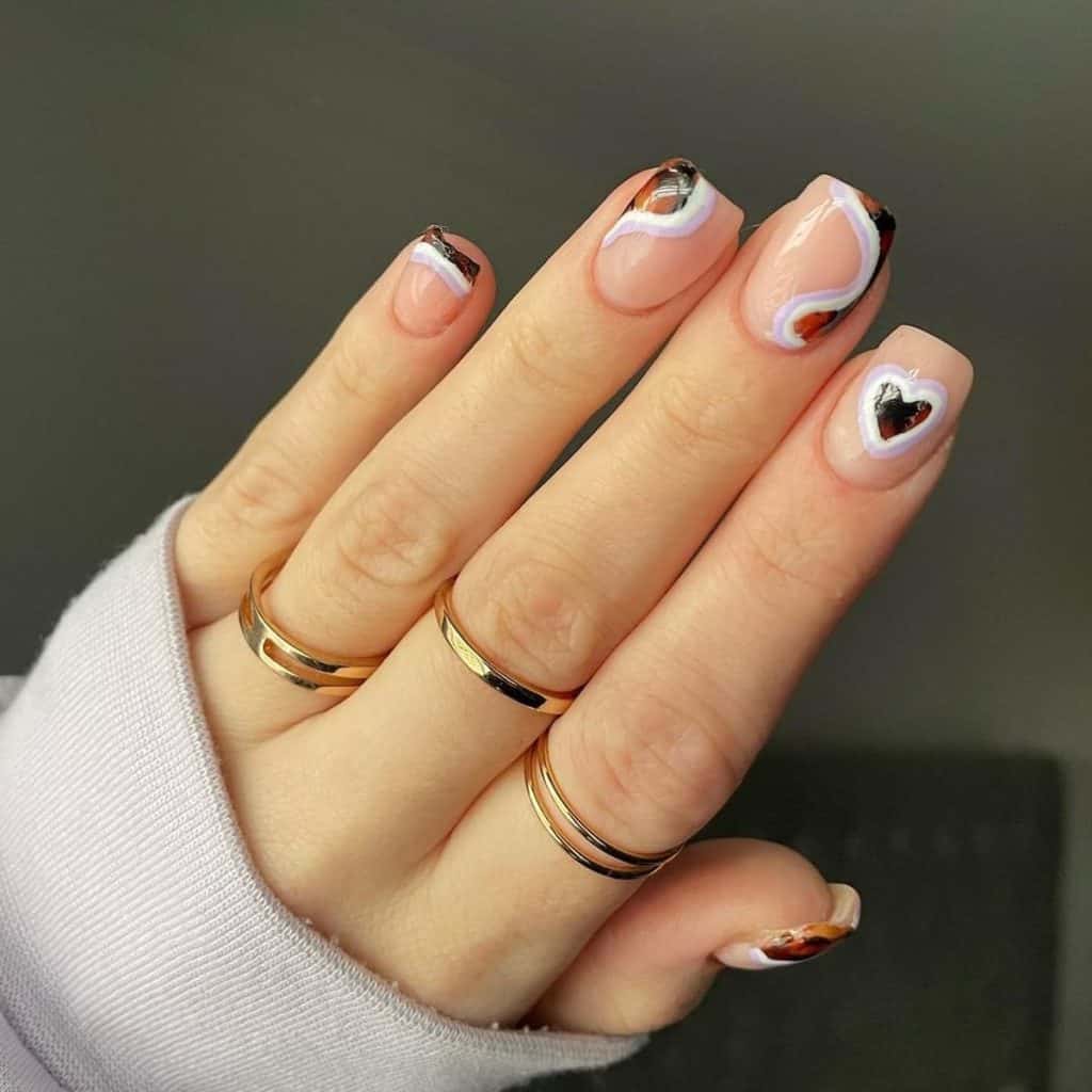 A woman's hand with blend of white, lilac, and tortoiseshell patterns to create French tips, side swirls, and a layered heart