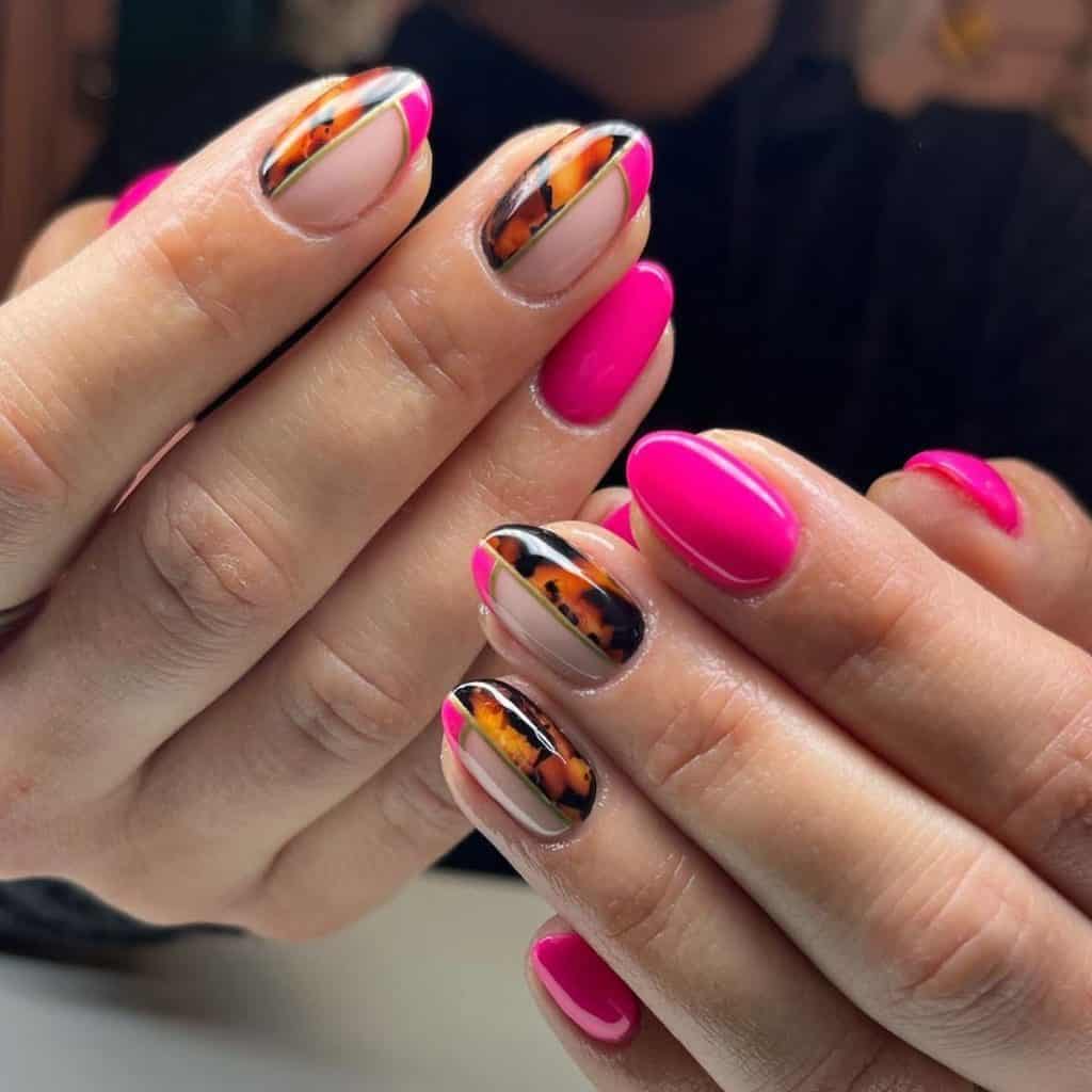A woman's hands with hot pink polish and tortoiseshell patterns that merge into an accent nail that’s half tortoiseshell and half French tip, all outlined in a rim of gold on a nude base