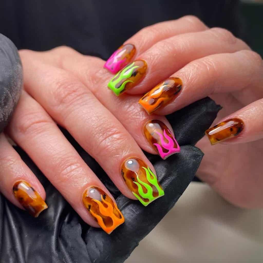 A woman's nails with neon spectacle with square nails painted in tortoiseshell patterns sporting neon shades of orange, pink, and green flame French tips