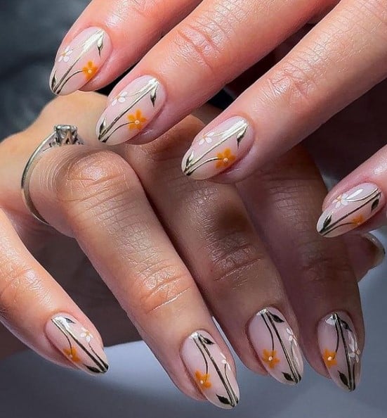 A woman's nude nails with gold centric vertical line brings life to each nail, mimicking a stem