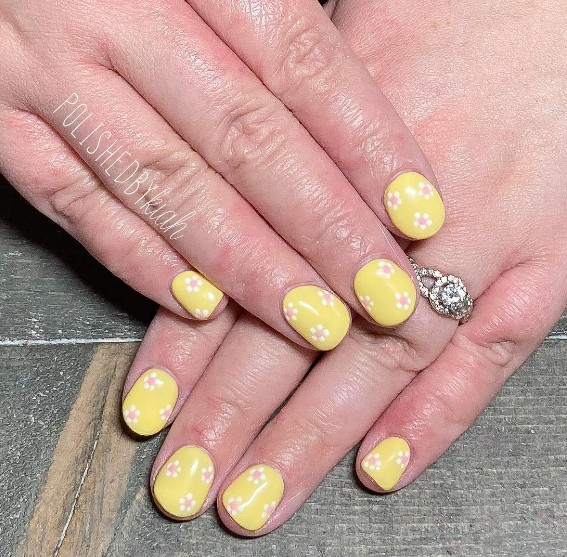 A woman's hands with a yellow flower design on them.
