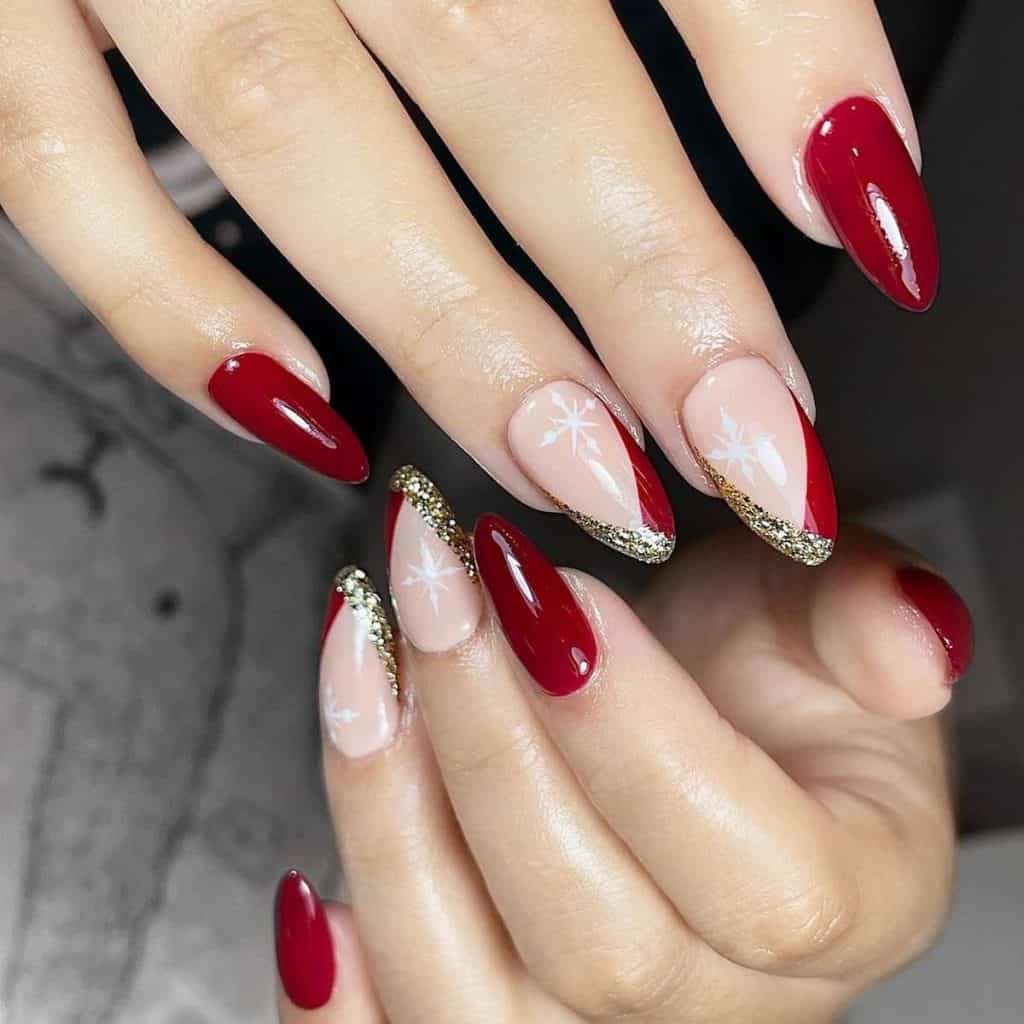 Deep red hues coat most of the nails, while nude accent nails sport a white solitary snowflake and showcase deep red and gold glitter to create V-shaped French tips.