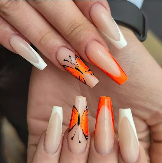 A woman with coffin nails holding a butterfly design.