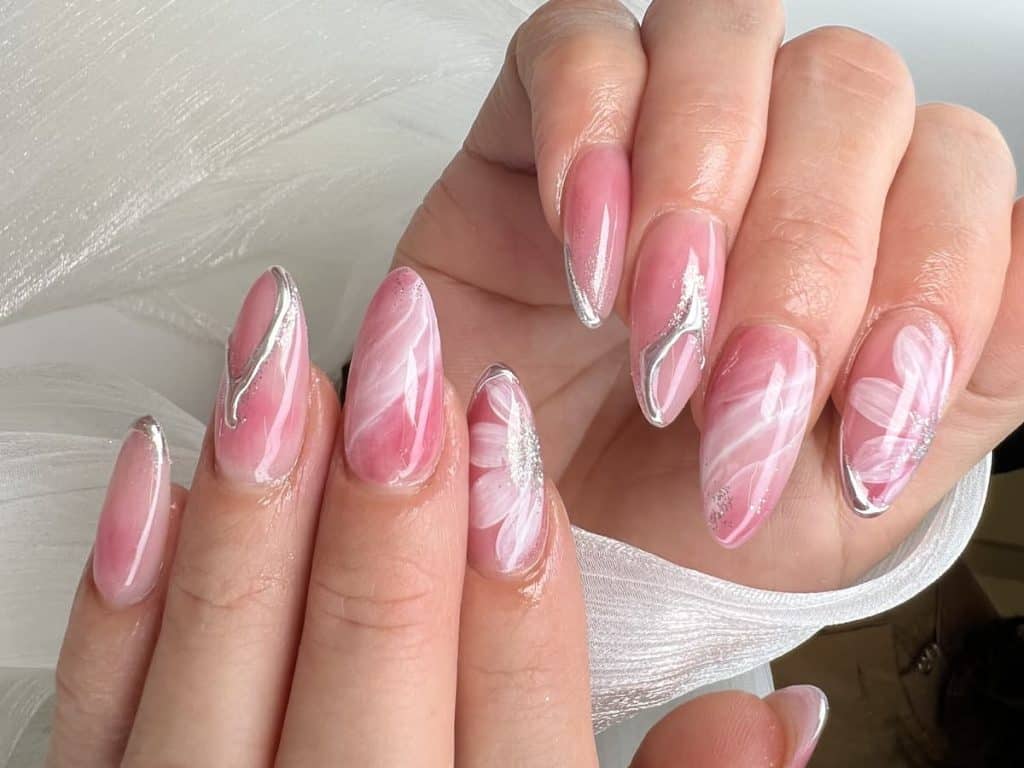 A woman's pink and white nails with white designs.
