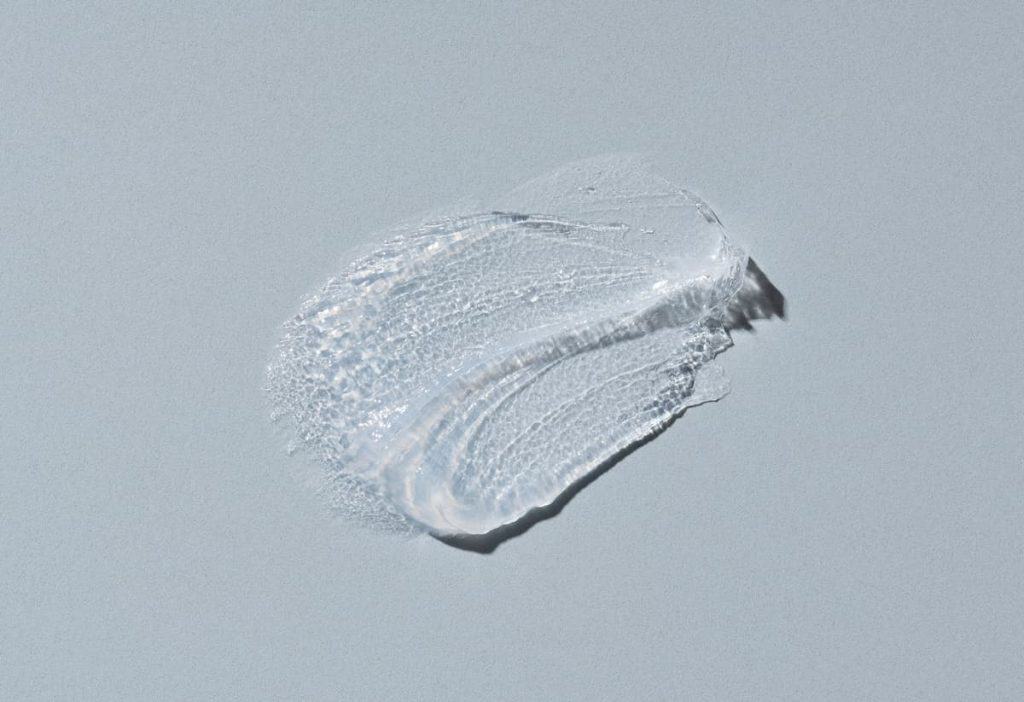 A close up of a aquaphor product smear on a gray surface.