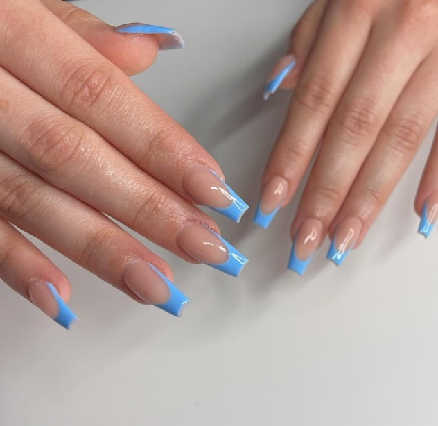 A woman's hands flaunting stunning coffin nails with a mesmerizing combination of blue and white shades.