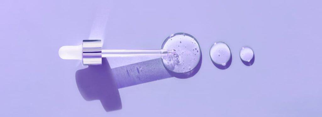 pipette drop of serum test on a purpule background