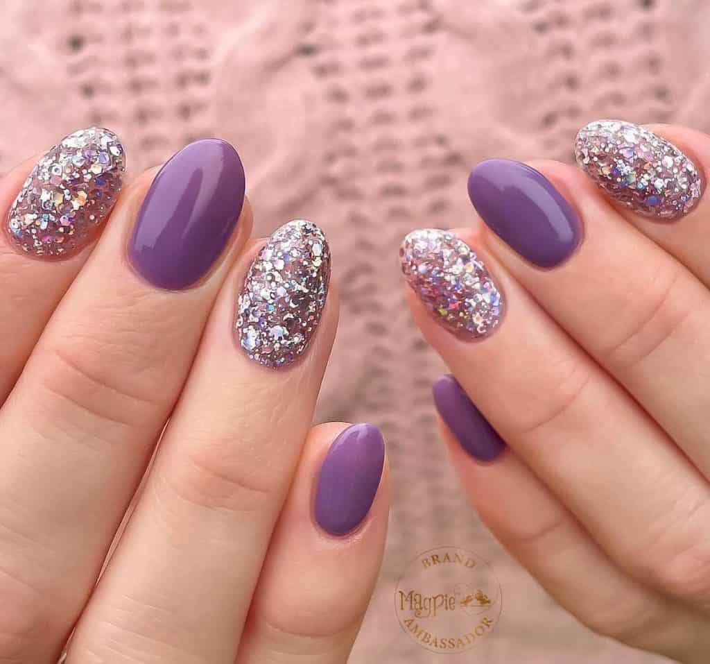 A woman's hands with purple and silver glitter nails.