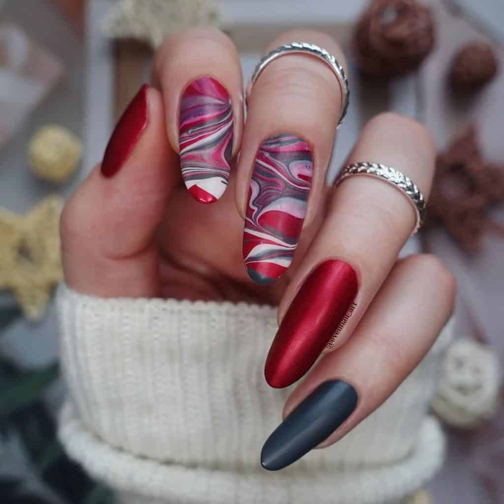 Solid black and red matte nails come to life when paired with nails that boast mesmerizing water marble art that blends black, red, white, and pink for an edgy yet elegant statement.