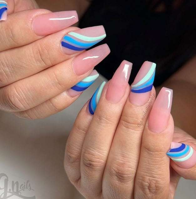 A woman's pink and blue coffin nails with a blue and white stripe.