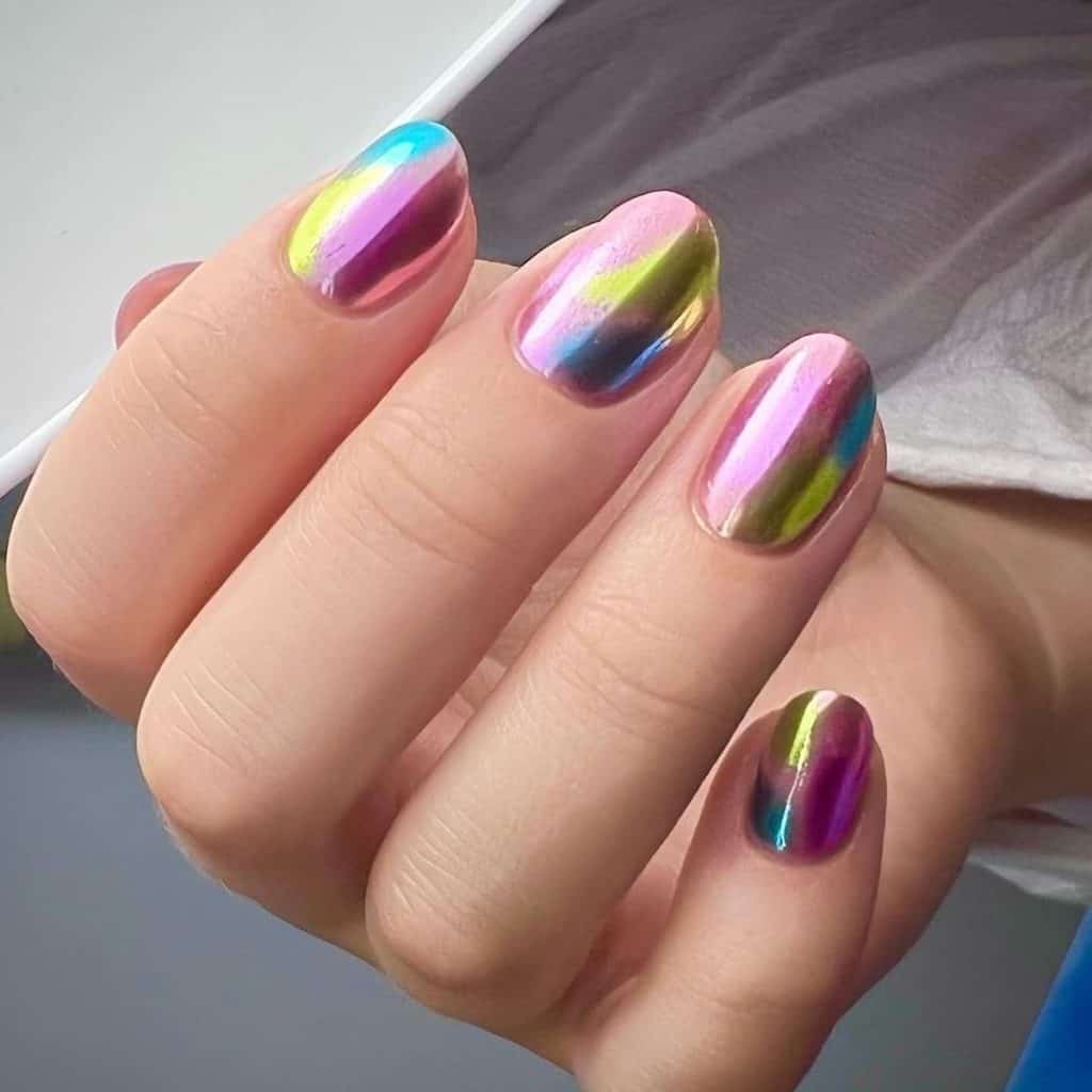 A woman's hand holding a pink unicorn chrome nails, where magical hues of blue, purple, and gold dance atop a pink base