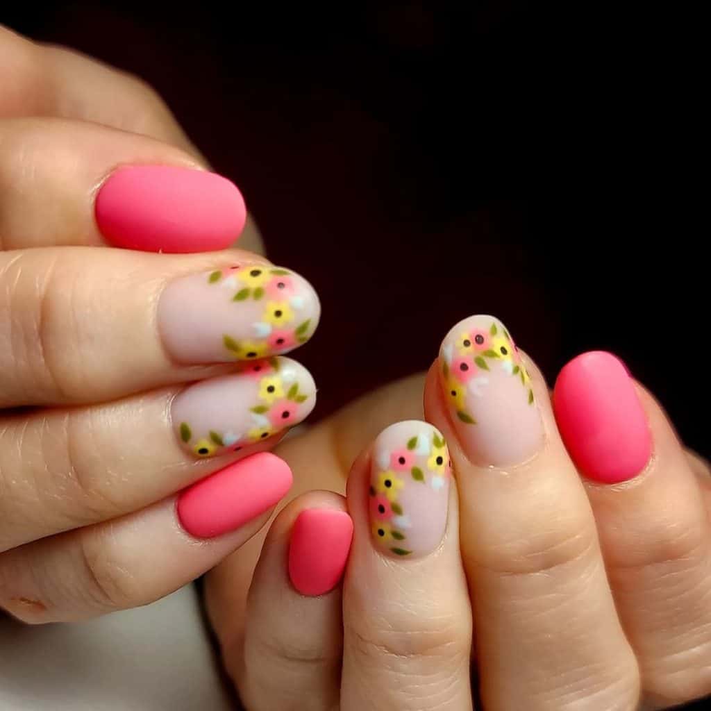 Matte gel nails in nude pink become gardens with borders of yellow, pink, and white flowers accented with gentle leaves. 