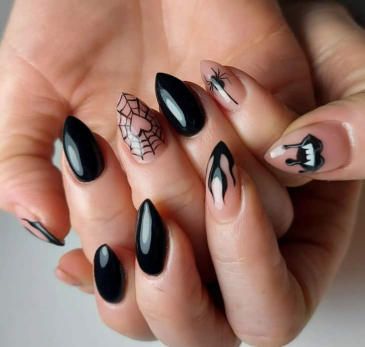 Glossy black short arrowhead nails bring the drama, while the nude accent nails take it up a notch with heart-centered spiderwebs, daring black flames, a hanging spider, and a vampire mouth oozing blood.