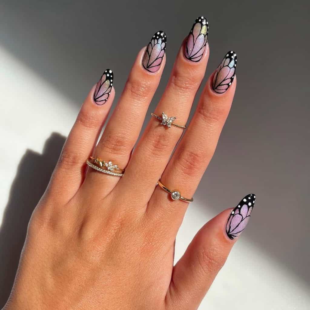 A woman's hand with iridescent lavender, each detailed with a delicate butterfly wing pattern in black polish that’s a great play on the French tip style