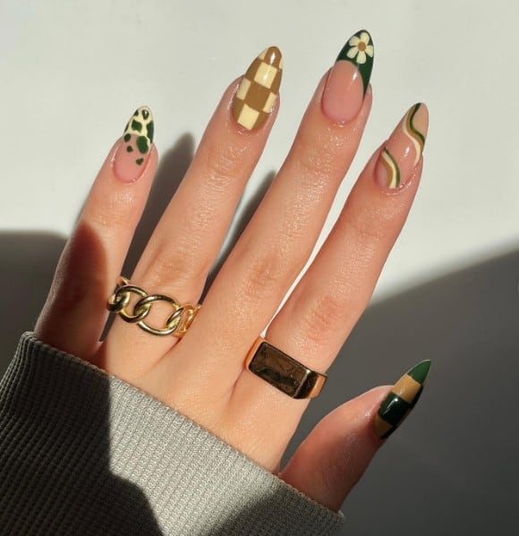 A playful mix adorns each almond-shaped nail: French tips grace two, with one featuring a flower and the other a cow print. 