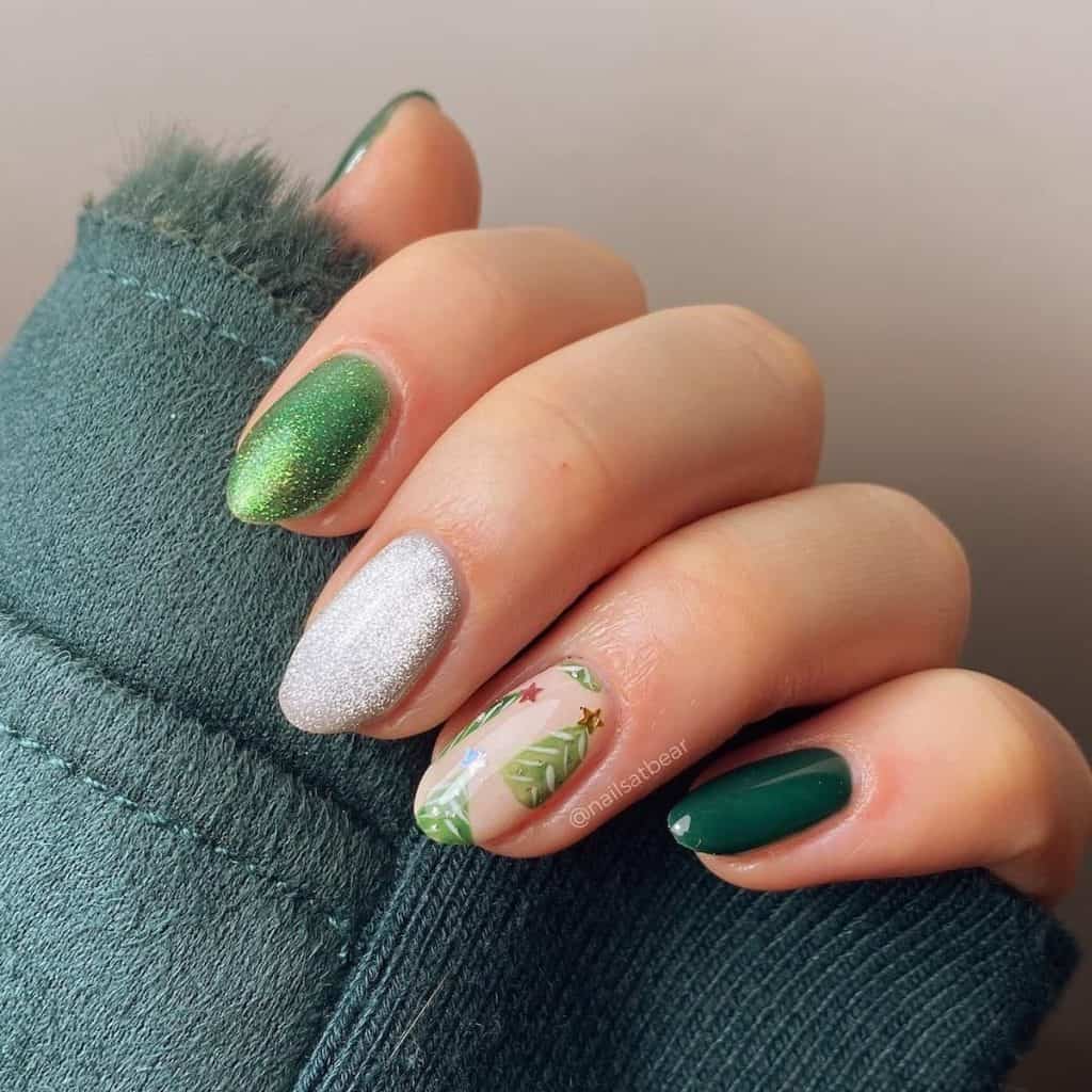 These green aesthetic Christmas nails parade in shades of emerald and glitter, with an accent nail proudly displaying a cartoon Christmas tree on a nude base. 
